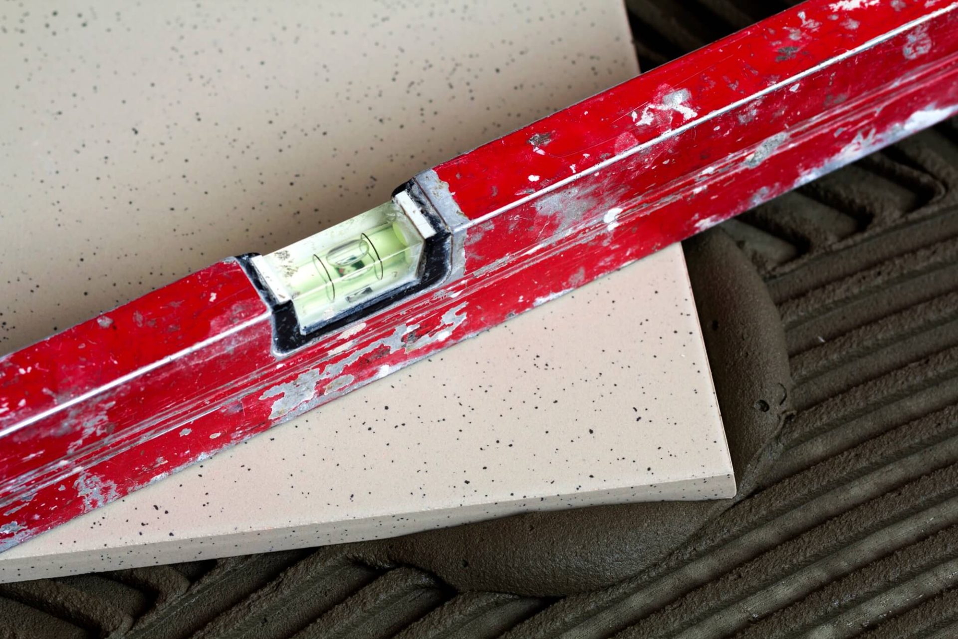 Kakelsättning pågår med fokus på precision och raka linjer.